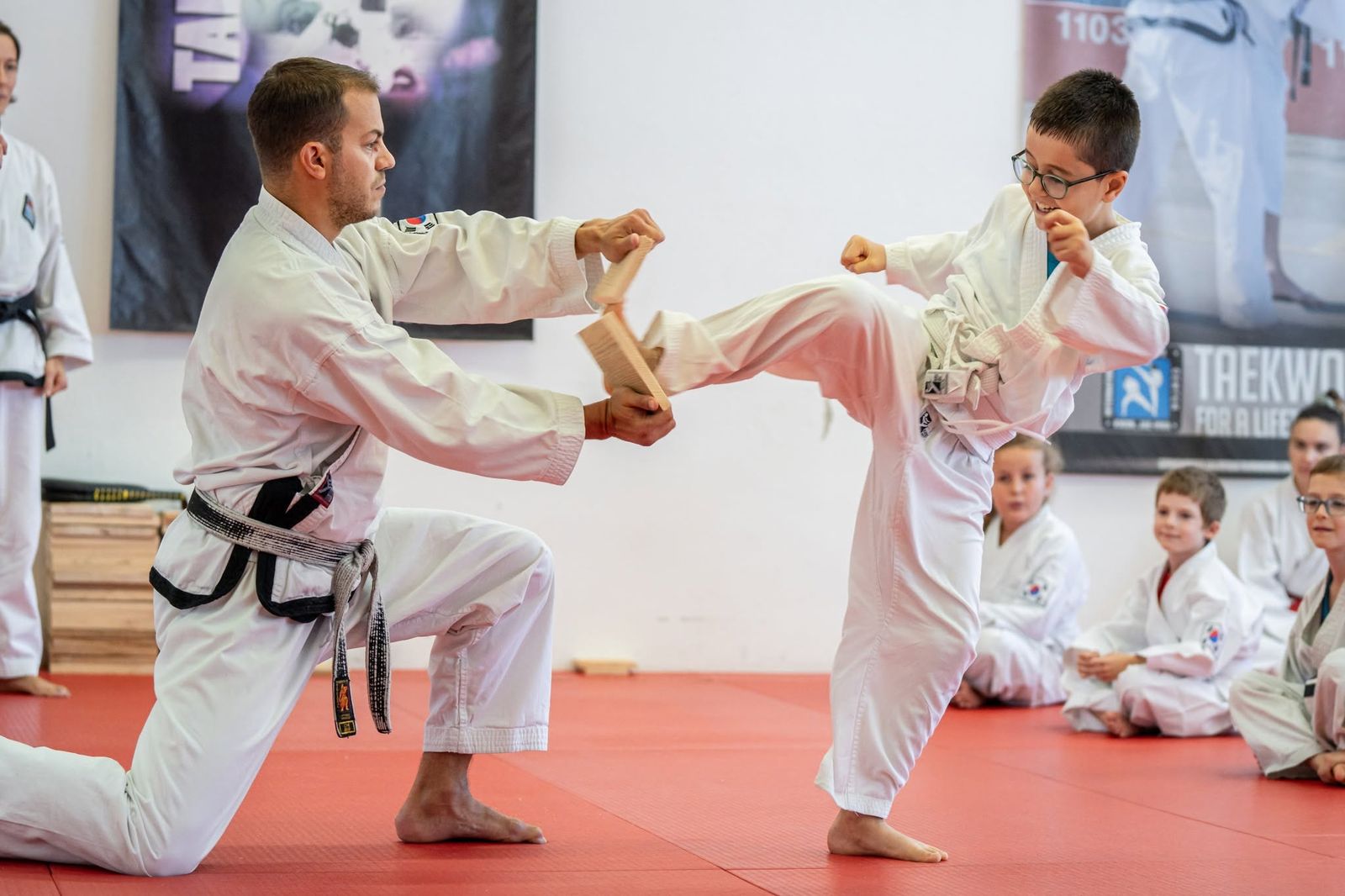Kind beim Bruchtest mit Kick — Taekwon-Do oder Karate für Kinder